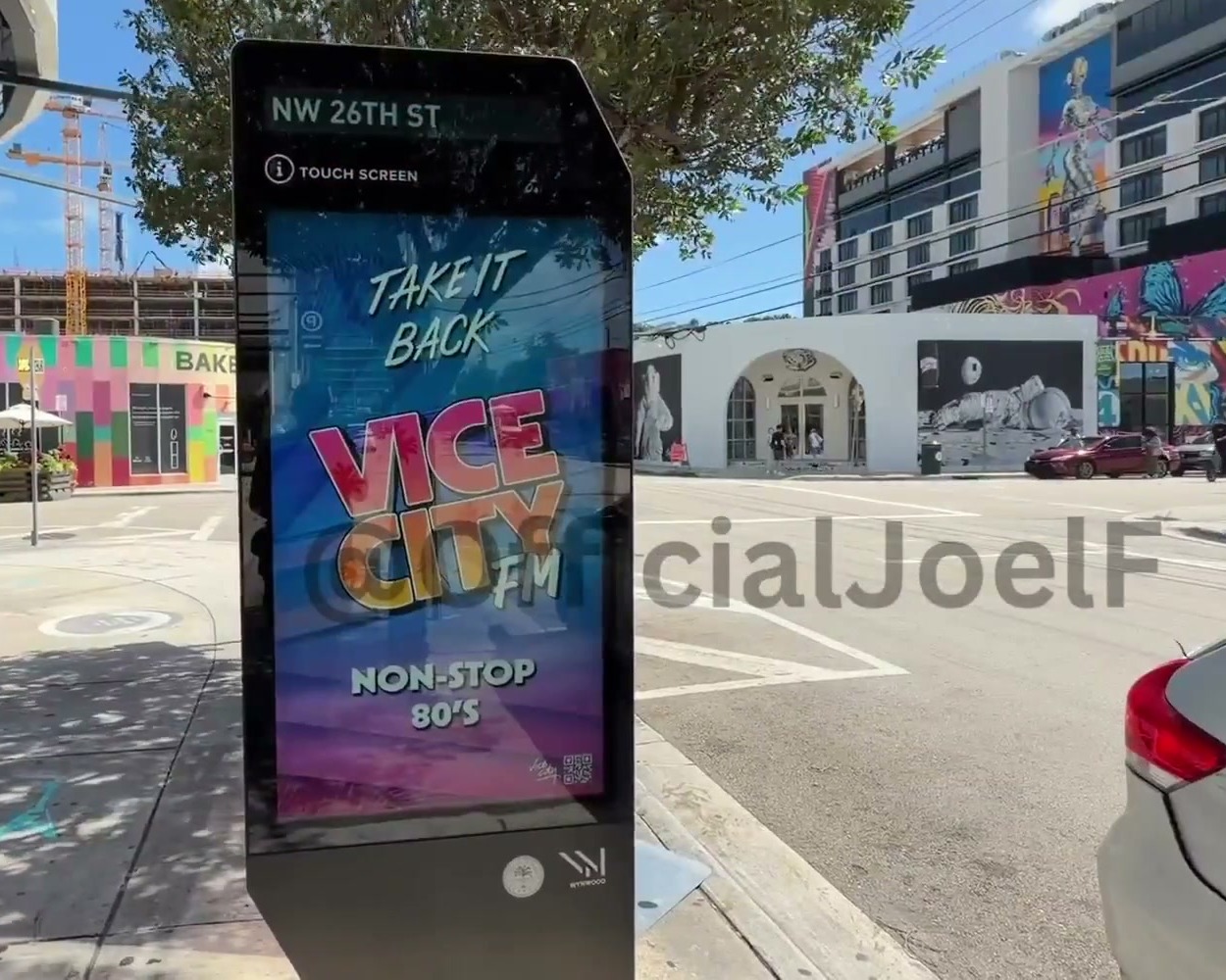 Digital kiosk on NW 26th St in Wynwood showing a pink and blue Vice City FM ad: 'Take it back' and 'Non-stop 80's'