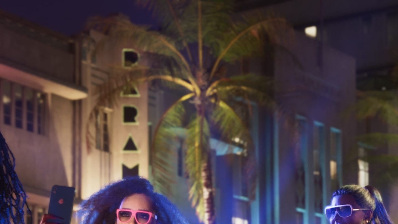 Paramour Hotel vertical neon between palms on Shore Drive at night
