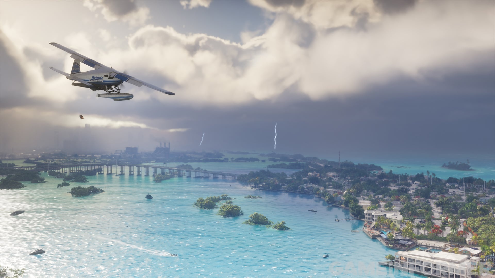Light aircraft flying over a turquoise bay with small islands and the city behind, under a cloudy sky.