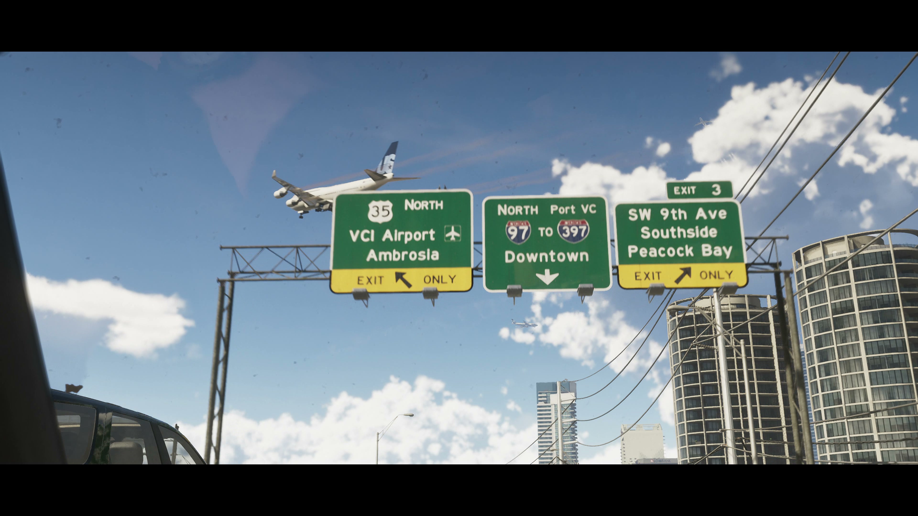 Highway gantry with exits to the airport, Downtown and Peacock Bay, and a plane coming in to land