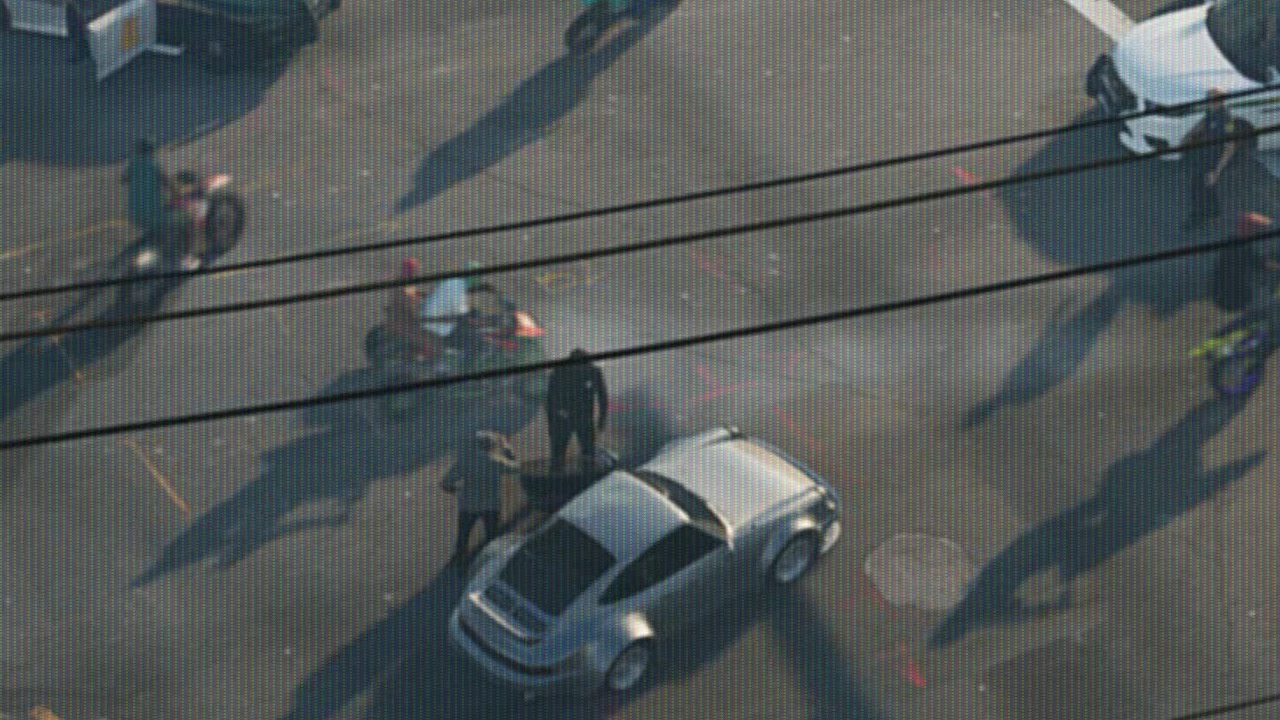Deportivo plateado visto desde un helicóptero en un cruce de Vice City, rodeado de policías y motos de cross, en el tráiler 1 de GTA VI