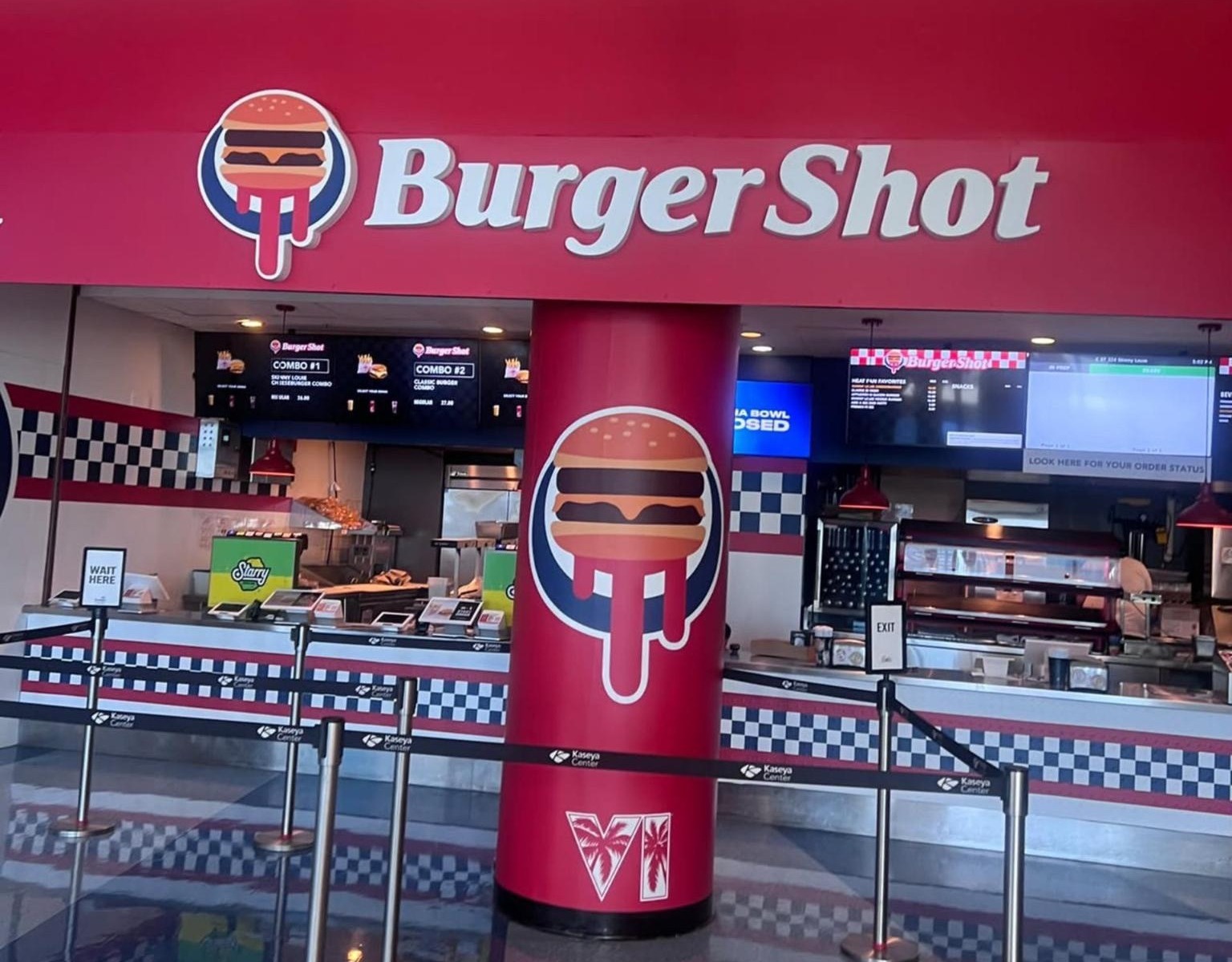 Kaseya Center food stand branded as Burger Shot, with the dripping burger logo, checkered floors and the "VI" logo on the pillar