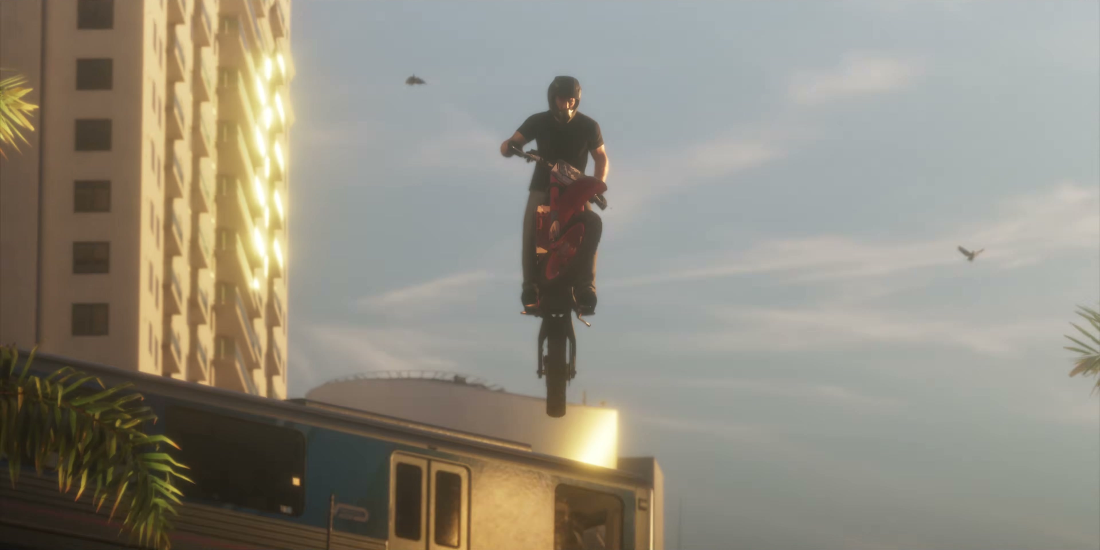 A helmeted rider jumps a dirt bike over a metro train