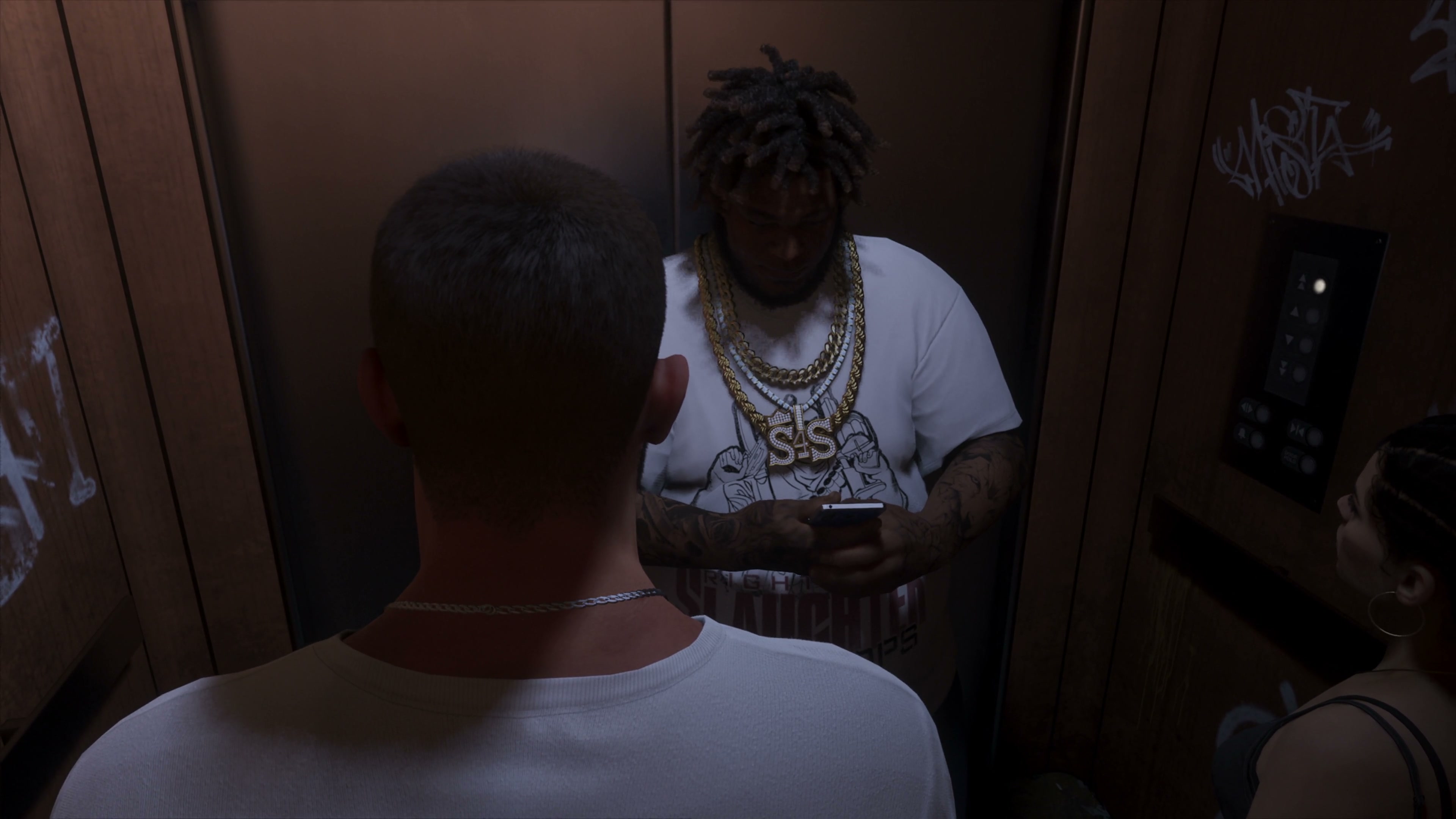 Three people ride in an elevator; one of them looks at a mobile phone.