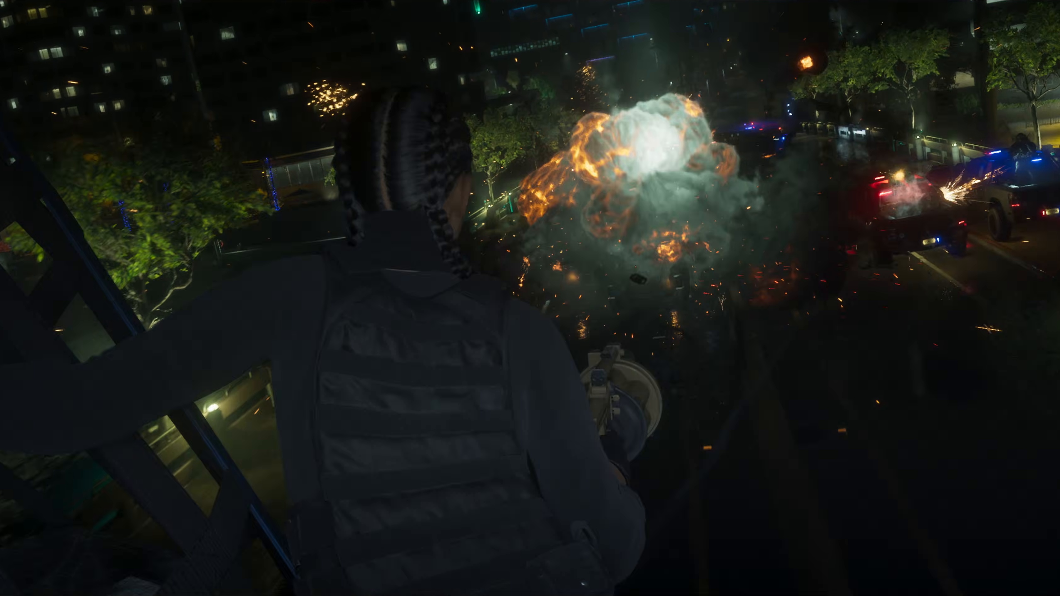 Braided figure in a vest fires from a fire escape as a vehicle explodes