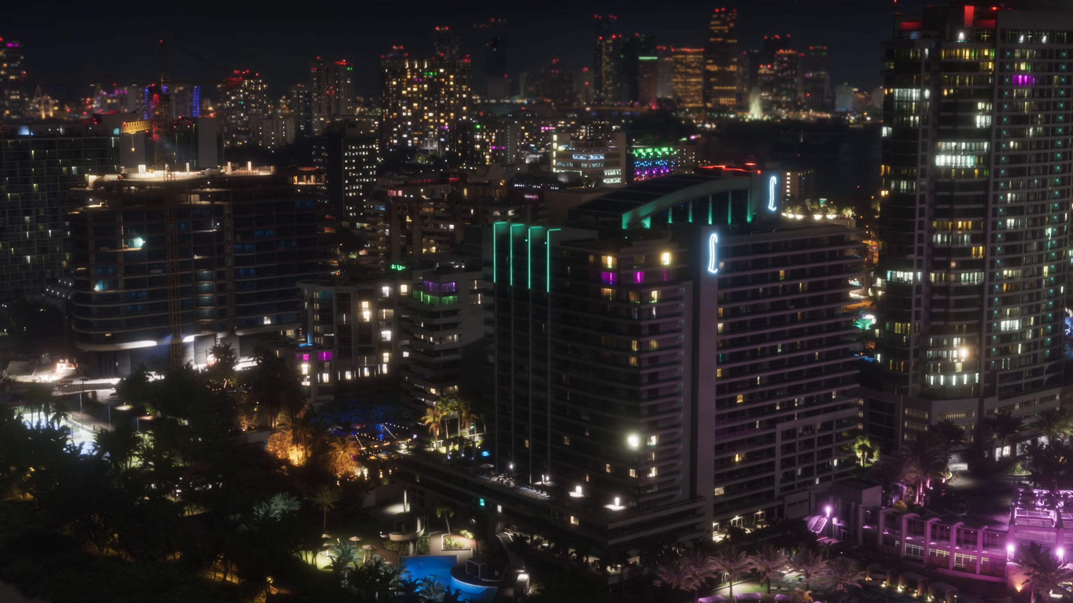 Lit hotel towers of Washington Beach at night with pools below
