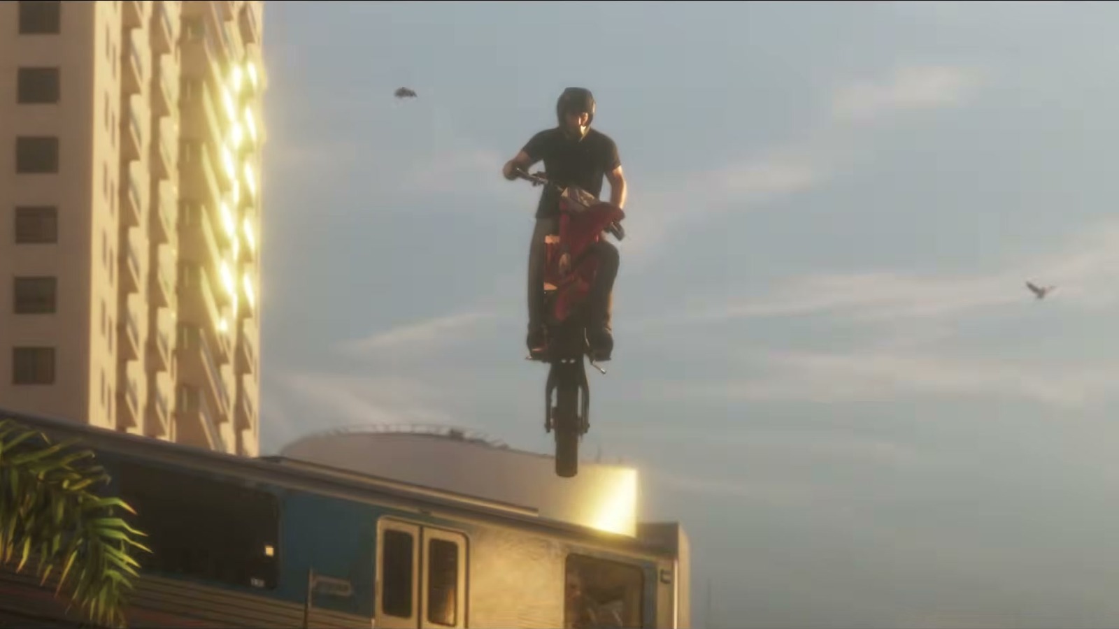 A dirt bike jumps off the elevated rail line next to a train, towers behind.