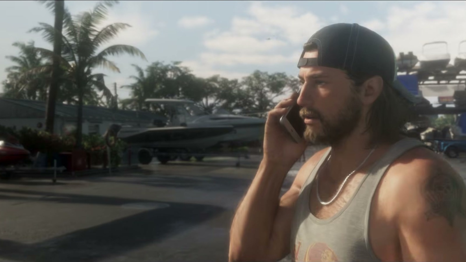 Jason on the phone in the marina parking lot, with stacked boats behind him.