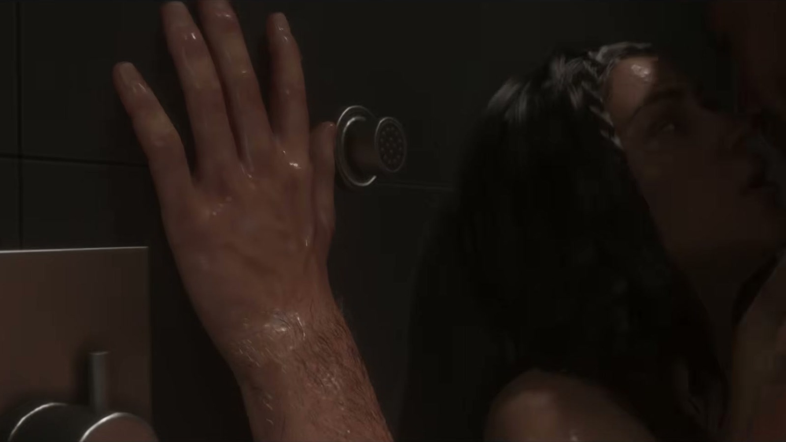 A wet hand on shower tiles as a long-haired woman kisses someone.