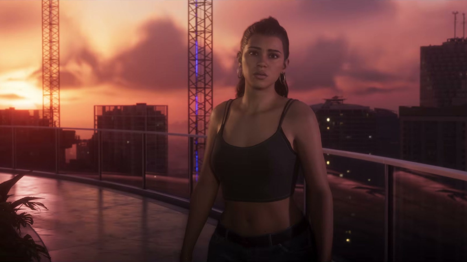 A woman with a ponytail on a terrace at sunset, cranes and towers behind.